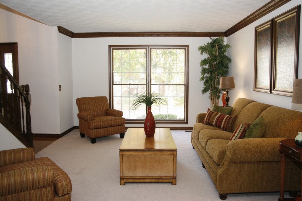 living room  open layout with wood crown molding and neutral paint. this offers the perfect space for a library, den or formal sitting area.